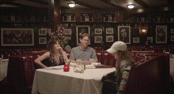 Movie still from “Flower” (2017), directed by Max Winkler – A group of people sitting at a table in a restaurant; Wide shot, Over the shoulder angle
