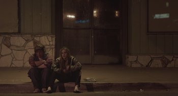 Movie still from “Flower” (2017), directed by Max Winkler – Two people sitting on a curb at night; Medium shot, Over the shoulder angle