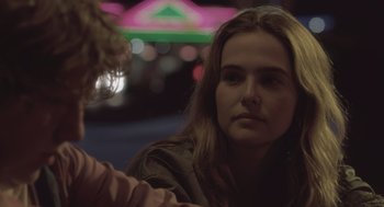 Movie still from “Flower” (2017), directed by Max Winkler – A woman sitting in front of a neon sign; Close Up shot, Over the shoulder angle