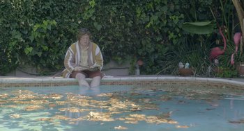 Movie still from “Flower” (2017), directed by Max Winkler – A man sitting on the edge of a swimming pool; Wide shot, High angle