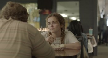 Movie still from “Flower” (2017), directed by Max Winkler – A woman sitting at a table with a bowl of food in front of her; Close Up shot, Over the shoulder angle