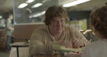 Movie still from “Flower” (2017), directed by Max Winkler – A person sitting at a table with a bowl of food; Close Up shot, Over the shoulder angle