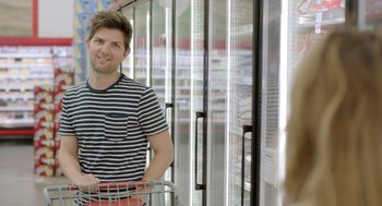 Movie still from “Flower” (2017), directed by Max Winkler – A man standing in front of a freezer in a grocery store; Medium shot, Over the shoulder angle