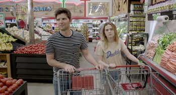 Movie still from “Flower” (2017), directed by Max Winkler – A man and a woman standing next to each other in a grocery store; Medium shot, Over the shoulder angle