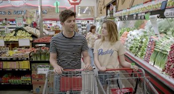 Movie still from “Flower” (2017), directed by Max Winkler – A man and a woman are standing in a grocery store; Medium shot, Over the shoulder angle