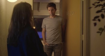 Movie still from “Flower” (2017), directed by Max Winkler – A man standing next to a woman in a room; Medium shot, Over the shoulder angle