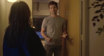 Movie still from “Flower” (2017), directed by Max Winkler – A man standing in front of a wall holding a pair of sticks; Medium shot, Over the shoulder angle