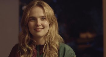 Movie still from “Flower” (2017), directed by Max Winkler – A woman with long blonde hair smiles at the camera; Close Up shot, Over the shoulder angle