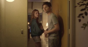 Movie still from “Flower” (2017), directed by Max Winkler – A man and a woman standing next to each other in a room; Medium shot, Over the shoulder angle