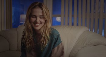 Movie still from “Flower” (2017), directed by Max Winkler – A woman sitting on top of a white couch; Close Up shot, Over the shoulder angle