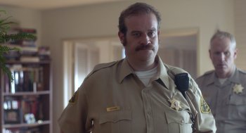 Movie still from “Flower” (2017), directed by Max Winkler – A man with a mustache wearing a police uniform; Close Up shot, Low angle