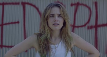 Movie still from “Flower” (2017), directed by Max Winkler – A woman with long hair is standing in front of a wall; Close Up shot, Over the shoulder angle