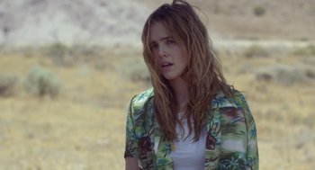 Movie still from “Flower” (2017), directed by Max Winkler – A young woman with long hair and a floral shirt looking to her left; Close Up shot, Over the shoulder angle