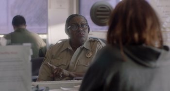 Movie still from “Flower” (2017), directed by Max Winkler – An older woman wearing glasses and a police uniform; Close Up shot, Over the shoulder angle