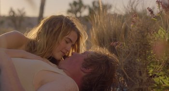 Movie still from “Flower” (2017), directed by Max Winkler – A man and a woman kissing in a field; Close Up shot, Over the shoulder angle