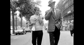 Movie still from “De Palma” (2015), directed by Jake Paltrow – An older man and a young woman walking down a street; Medium shot, Low angle