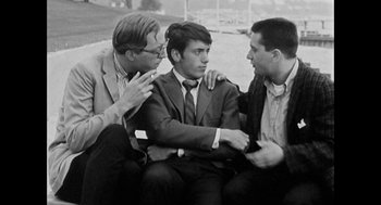 Movie still from “De Palma” (2015), directed by Jake Paltrow – A group of men sitting next to each other on the ground; Medium shot, High angle