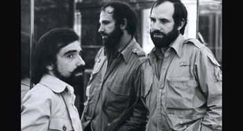 Movie still from “De Palma” (2015), directed by Jake Paltrow – A group of men standing next to each other in front of a building; Close Up shot, Low angle