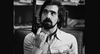 Movie still from “De Palma” (2015), directed by Jake Paltrow – Black and white photograph of a man holding a gun; Close Up shot, Low angle