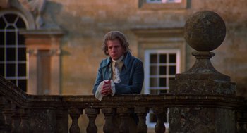 Movie still from “De Palma” (2015), directed by Jake Paltrow – A man leaning on a railing in front of a building; Medium shot, Low angle