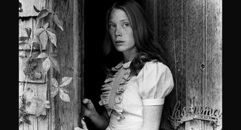 Movie still from “De Palma” (2015), directed by Jake Paltrow – A young woman standing in front of a wooden door; Close Up shot, Low angle