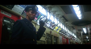 Movie still from “De Palma” (2015), directed by Jake Paltrow – A man in a police uniform standing in front of a train; Medium shot, Low angle