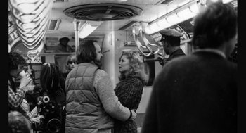 Movie still from “De Palma” (2015), directed by Jake Paltrow – A man and a woman standing next to each other on a train; Medium shot, Over the shoulder angle