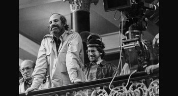 Movie still from “De Palma” (2015), directed by Jake Paltrow – A man and a woman standing next to each other on a balcony; Medium shot, Low angle