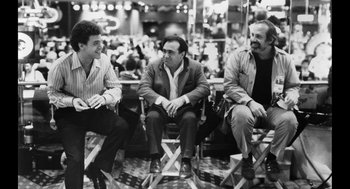 Movie still from “De Palma” (2015), directed by Jake Paltrow – A group of men sitting next to each other on chairs; Medium shot, Low angle