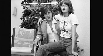 Movie still from “De Palma” (2015), directed by Jake Paltrow – A man and a woman pose for a picture; Medium shot, Low angle