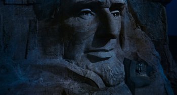 Movie still from “De Palma” (2015), directed by Jake Paltrow – Image of the face of abraham lincoln carved into the side of a mountain; Extreme Close Up shot, Low angle
