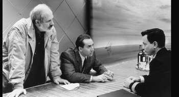 Movie still from “De Palma” (2015), directed by Jake Paltrow – Two men sitting at a table talking to each other; Medium shot, Over the shoulder angle