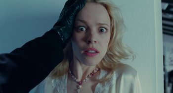 Movie still from “De Palma” (2015), directed by Jake Paltrow – A woman in a white robe is holding her hand up to her head; Close Up shot, Overhead angle