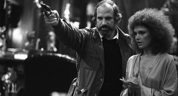 Movie still from “De Palma” (2015), directed by Jake Paltrow – A black and white photo of a man and a woman holding a gun; Close Up shot, Low angle