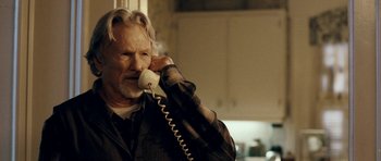 Movie still from “Deadfall” (2012), directed by Stefan Ruzowitzky – An older man talking on a phone while standing in a kitchen; Close Up shot, Over the shoulder angle