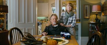 Movie still from “Deadfall” (2012), directed by Stefan Ruzowitzky – An older man sitting at a table with a woman; Medium shot, Over the shoulder angle