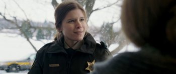 Movie still from “Deadfall” (2012), directed by Stefan Ruzowitzky – A woman in a police uniform talking to a person; Close Up shot, Over the shoulder angle