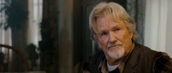 Movie still from “Deadfall” (2012), directed by Stefan Ruzowitzky – An older man with white hair and a white beard; Close Up shot, Over the shoulder angle