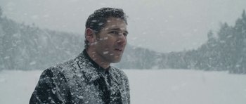 Movie still from “Deadfall” (2012), directed by Stefan Ruzowitzky – A man standing in the snow looking out a window; Close Up shot, Low angle
