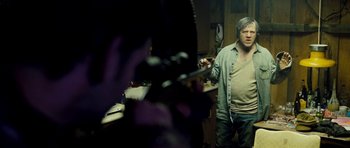 Movie still from “Deadfall” (2012), directed by Stefan Ruzowitzky – A man standing in front of a mirror holding a knife; Medium shot, Over the shoulder angle
