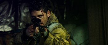 Movie still from “Deadfall” (2012), directed by Stefan Ruzowitzky – A man in a yellow jacket holding a camera; Close Up shot, Over the shoulder angle