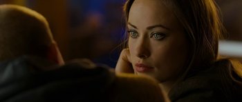 Movie still from “Deadfall” (2012), directed by Stefan Ruzowitzky – A beautiful young woman with blue eyes looking at the camera; Close Up shot, Over the shoulder angle
