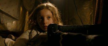Movie still from “Deadfall” (2012), directed by Stefan Ruzowitzky – A young girl sitting in a chair looking at the camera; Close Up shot, Low angle