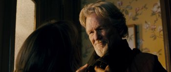 Movie still from “Deadfall” (2012), directed by Stefan Ruzowitzky – An older man is adjusting his tie while a woman looks on; Close Up shot, Over the shoulder angle