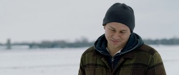 Movie still from “Deadfall” (2012), directed by Stefan Ruzowitzky – A man wearing a winter coat and a hat; Close Up shot, Over the shoulder angle