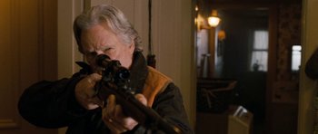 Movie still from “Deadfall” (2012), directed by Stefan Ruzowitzky – An older man is holding a rifle in his hands; Close Up shot, Over the shoulder angle