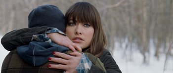 Movie still from “Deadfall” (2012), directed by Stefan Ruzowitzky – A woman holding a man in her arms in the snow; Close Up shot, Over the shoulder angle