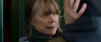 Movie still from “Deadfall” (2012), directed by Stefan Ruzowitzky – An older woman with blue eyes looking at the camera; Close Up shot, Over the shoulder angle