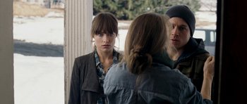 Movie still from “Deadfall” (2012), directed by Stefan Ruzowitzky – A woman standing in front of two other people; Close Up shot, Over the shoulder angle