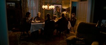 Movie still from “Deadfall” (2012), directed by Stefan Ruzowitzky – A group of people sitting around a table in a room; Wide shot, High angle